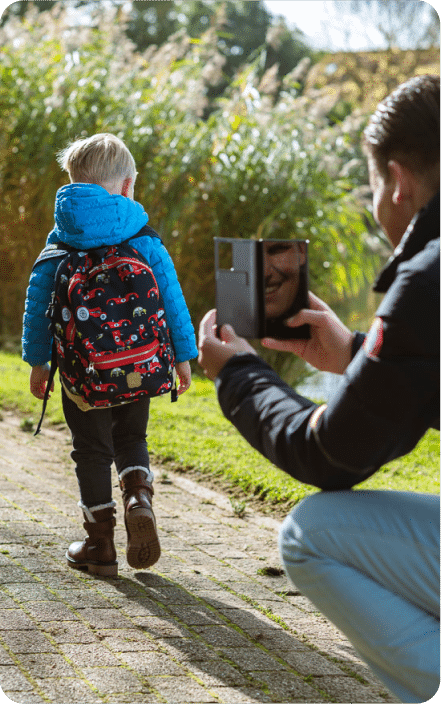 A parent photographs a child using his backpack